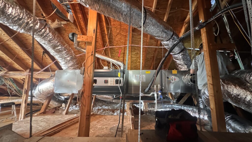 High efficiency air conditioner and residential attic ductwork